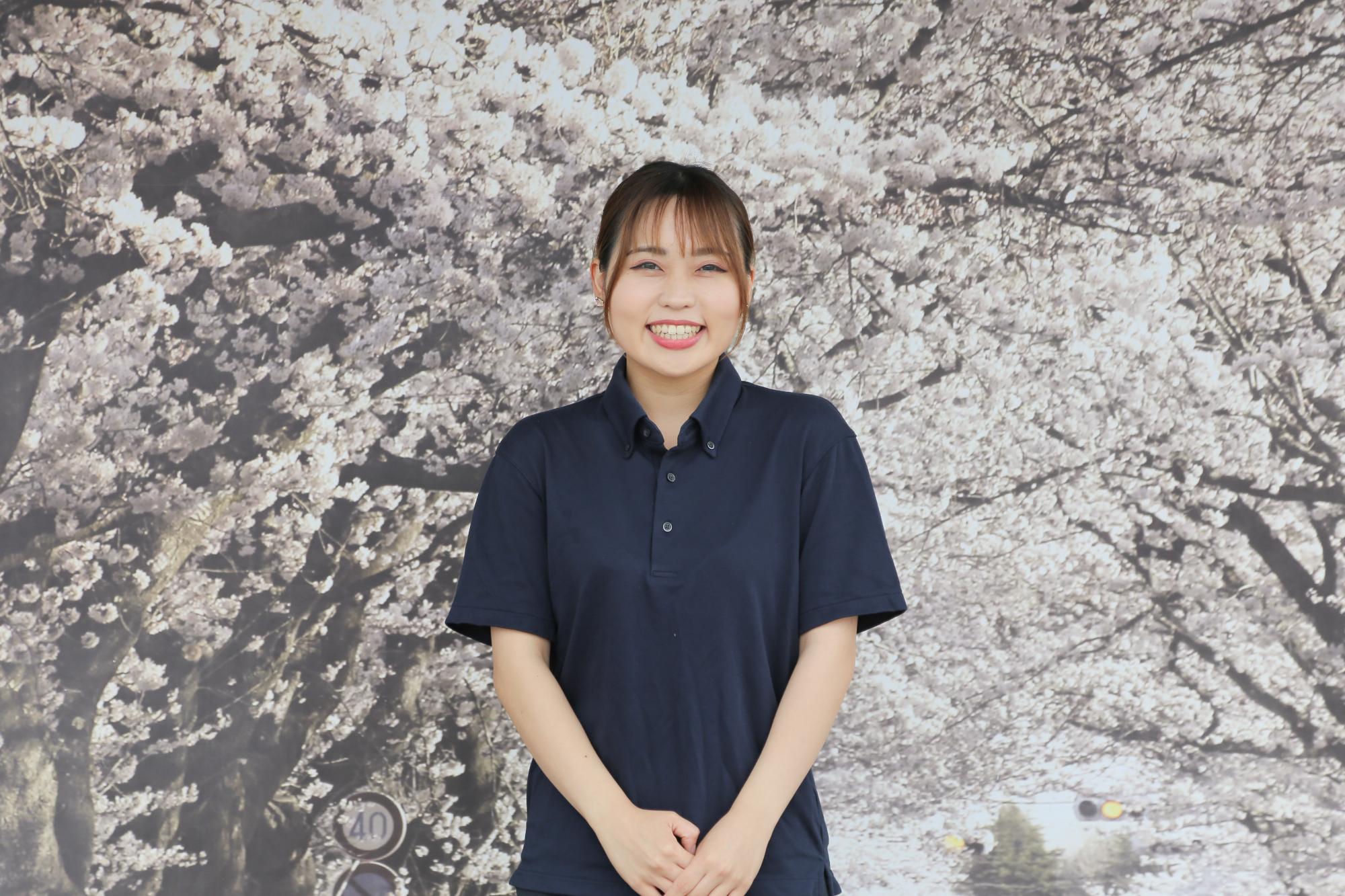 夜の森の桜をバックに笑顔の会田 瞳さん
