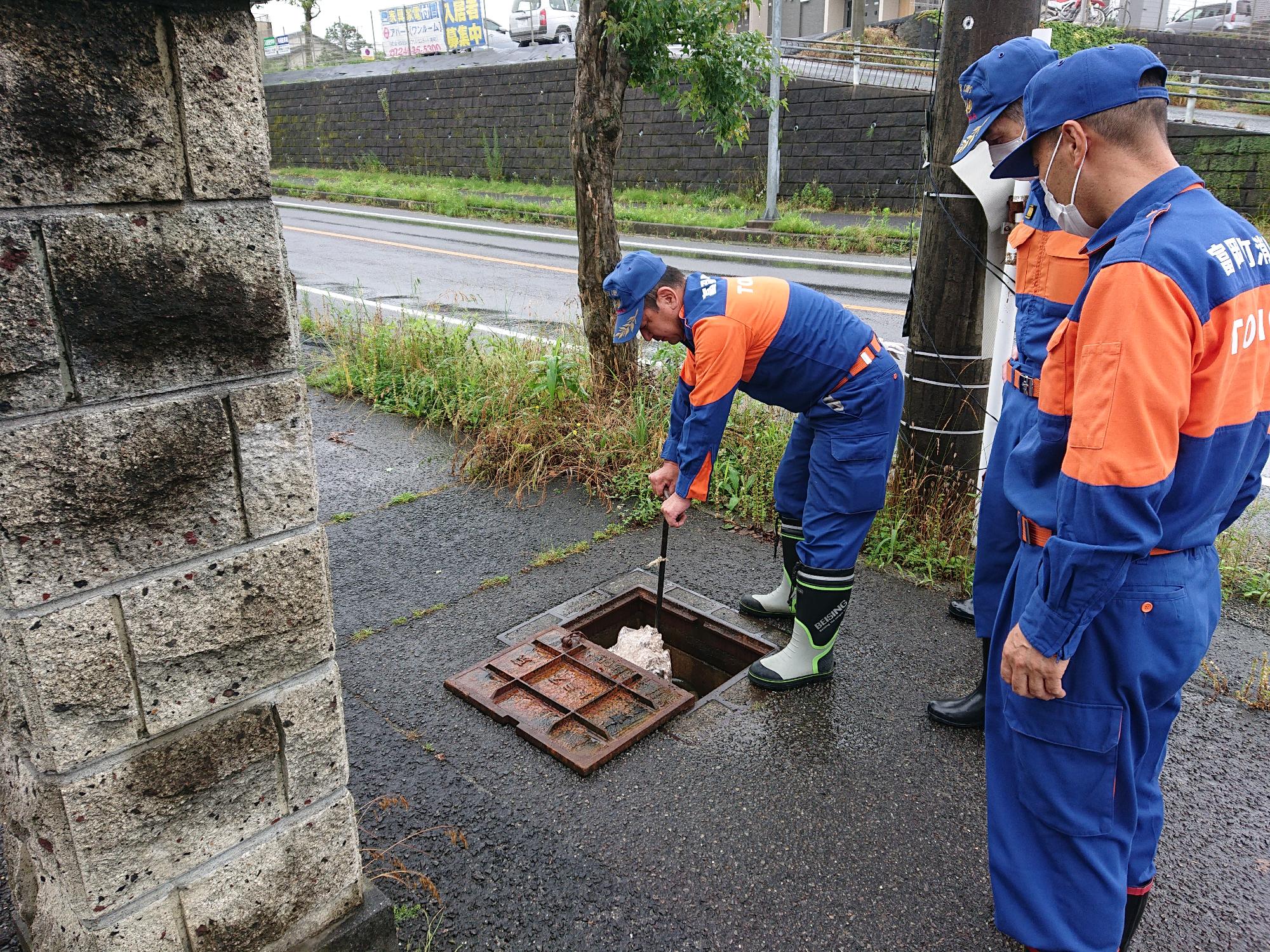 消火栓を慣れた手つきで点検するベテラン団員